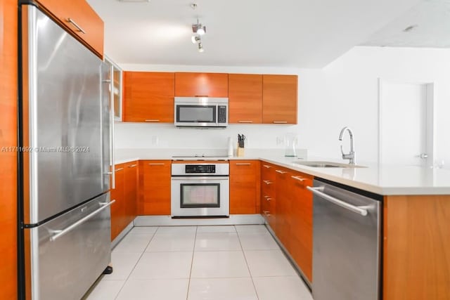 kitchen with sink, light tile patterned floors, and appliances with stainless steel finishes