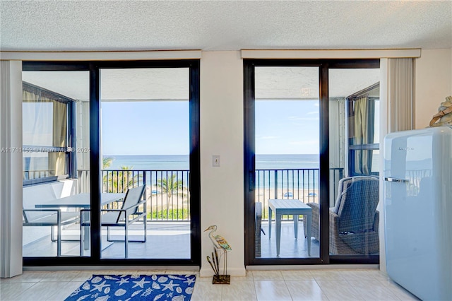 doorway to outside featuring tile patterned floors and a water view