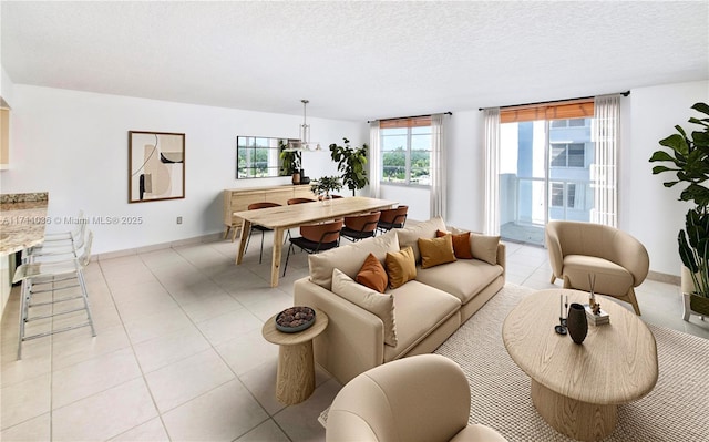 living area with light tile patterned floors, baseboards, and a textured ceiling