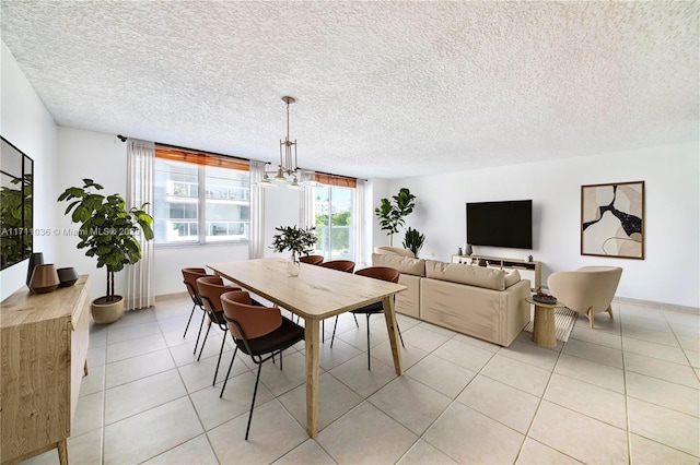 dining space with a chandelier, a textured ceiling, and light tile patterned floors