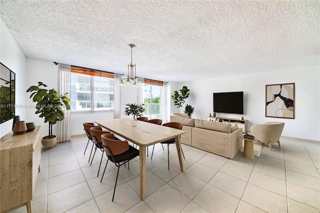 dining room with a notable chandelier, a textured ceiling, and light tile patterned floors