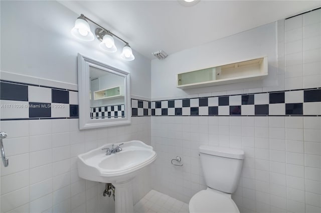 half bathroom with toilet and tile walls