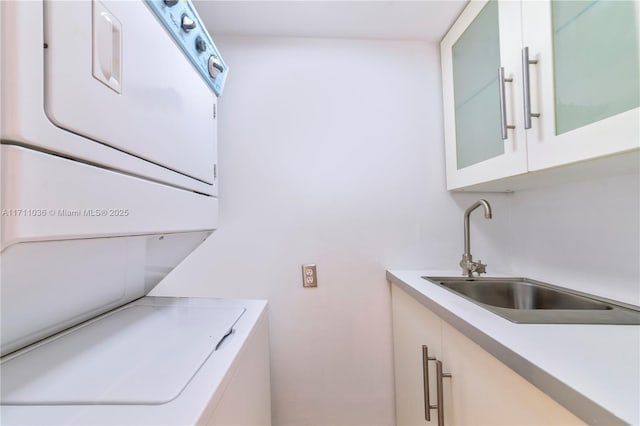 laundry room with a sink and stacked washer and clothes dryer