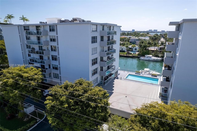 view of building exterior featuring a community pool and a water view