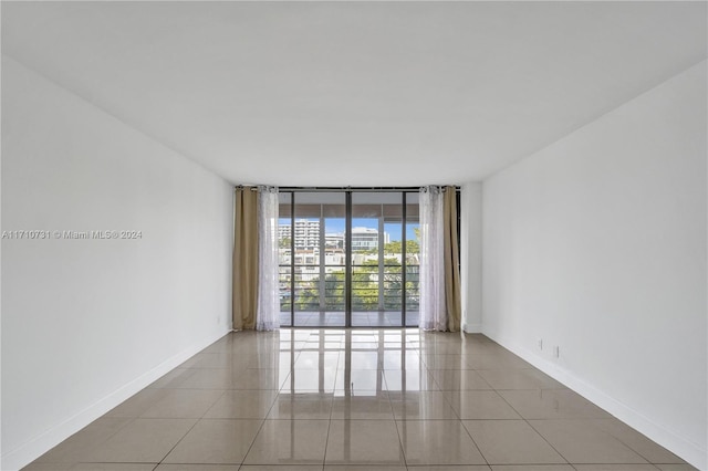 tiled spare room with floor to ceiling windows