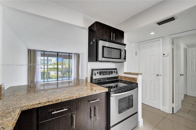 kitchen with light tile patterned flooring, light stone counters, dark brown cabinetry, and stainless steel appliances