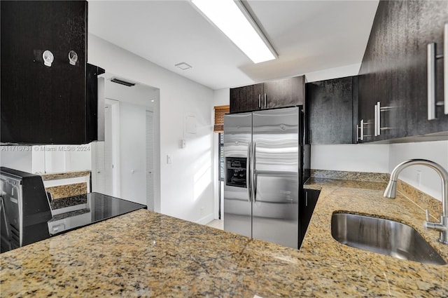 kitchen featuring dark brown cabinetry, stainless steel fridge with ice dispenser, and sink