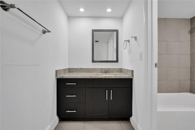 bathroom with tile patterned floors, vanity, and tiled shower / bath combo