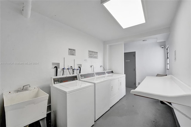 clothes washing area with separate washer and dryer and sink