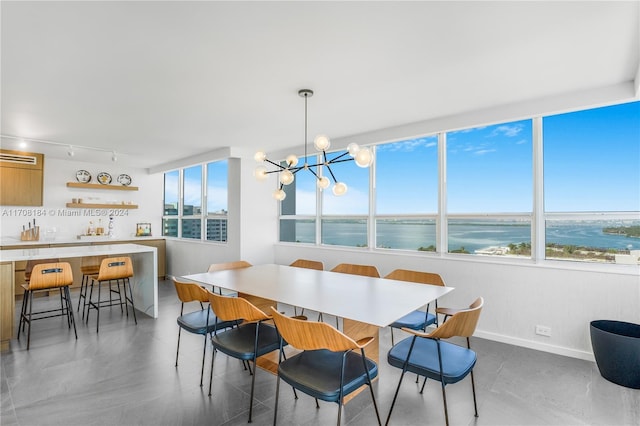 dining room featuring a chandelier and a water view