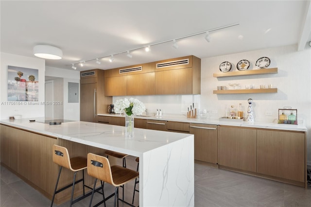 kitchen with a kitchen breakfast bar, paneled refrigerator, black electric cooktop, and light stone counters