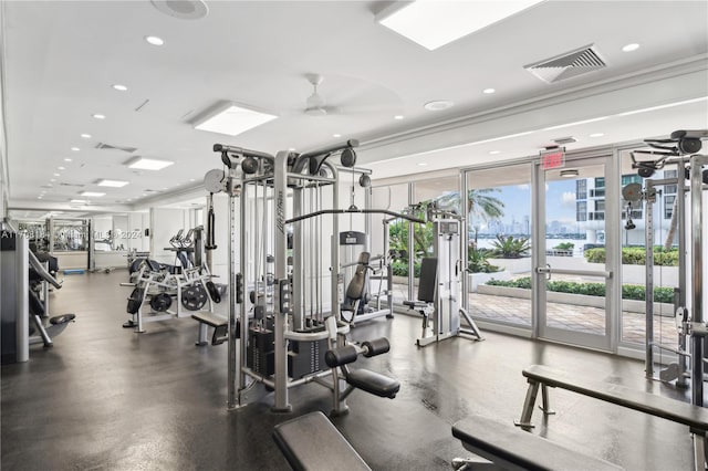 gym with ceiling fan, expansive windows, and ornamental molding