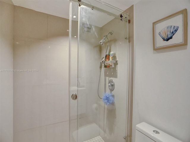 bathroom with toilet and a shower with shower door