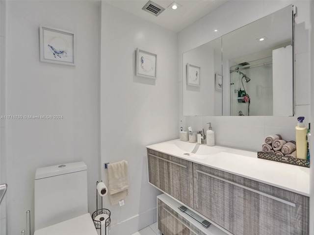 bathroom featuring vanity, toilet, and walk in shower