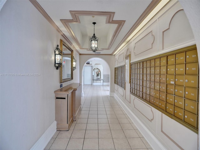 corridor featuring an inviting chandelier, crown molding, a mail area, and light tile patterned flooring