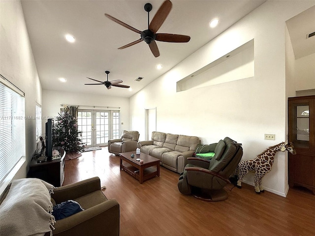 living room with ceiling fan, hardwood / wood-style floors, high vaulted ceiling, and french doors