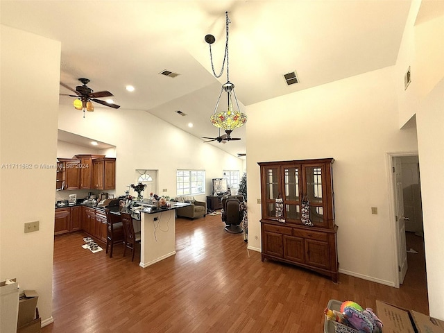 living room featuring dark hardwood / wood-style floors, high vaulted ceiling, and ceiling fan