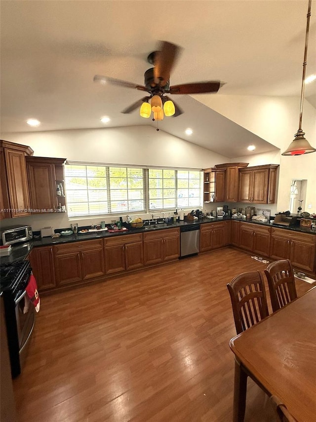 kitchen featuring stainless steel dishwasher, vaulted ceiling, dark wood-type flooring, decorative light fixtures, and black gas stove