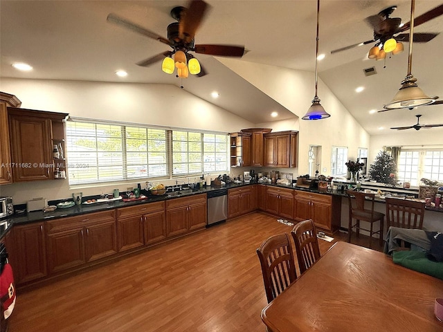 kitchen with hanging light fixtures, light hardwood / wood-style flooring, high vaulted ceiling, and stainless steel dishwasher