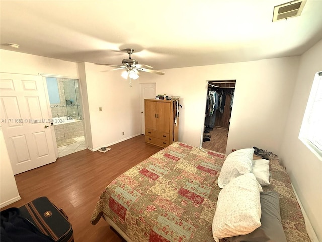 bedroom with hardwood / wood-style floors, ceiling fan, a spacious closet, connected bathroom, and a closet