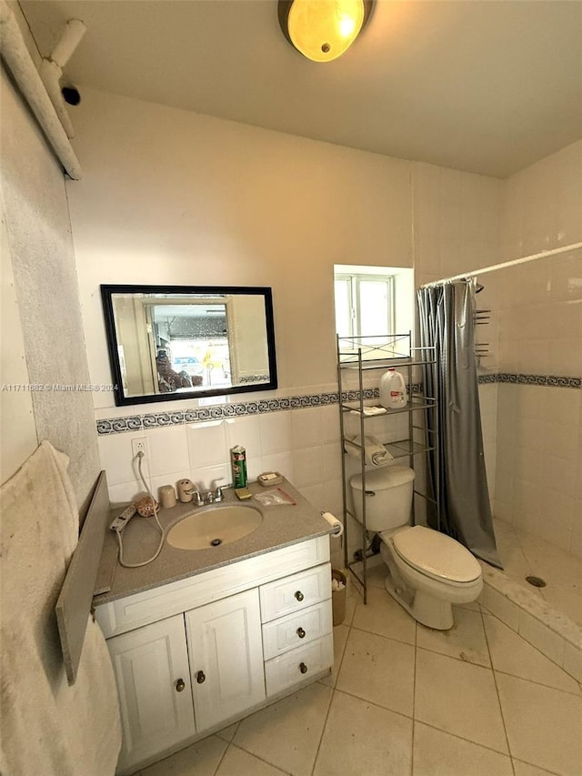 bathroom featuring vanity, tile patterned floors, a shower with curtain, toilet, and tile walls