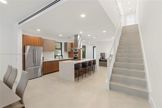 909 NE 16th Ave, Fort Lauderdale, FL 33304 - kitchen featuring stainless steel appliances, modern cabinets, island range hood, recessed lighting, and a center island