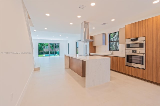 kitchen featuring island range hood, black electric stovetop, sink, double oven, and a kitchen island