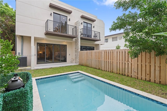 909 NE 16th Ave, Fort Lauderdale, FL 33304 - rear view of house with central AC unit, fence, stucco siding, and a balcony