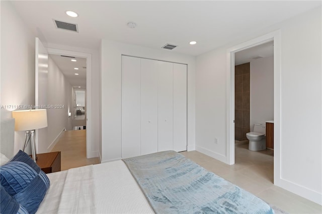 bedroom featuring connected bathroom, a closet, and light tile patterned flooring