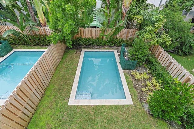 view of swimming pool with a lawn