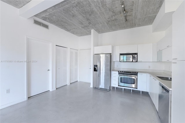 kitchen featuring white cabinets, sink, appliances with stainless steel finishes, and concrete floors