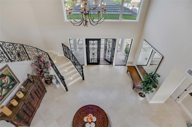 entrance foyer featuring a towering ceiling and a chandelier