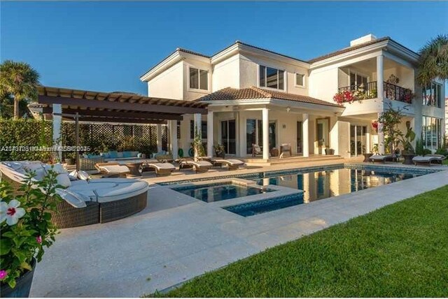 back of property with a fenced in pool, a patio, and a pergola