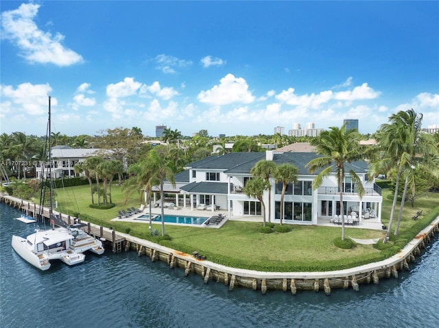 back of property with a water view, a balcony, a yard, and a patio