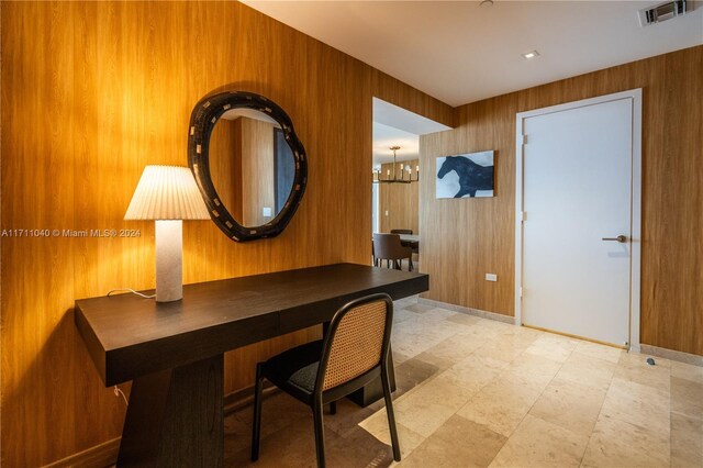 interior space featuring wood walls and an inviting chandelier