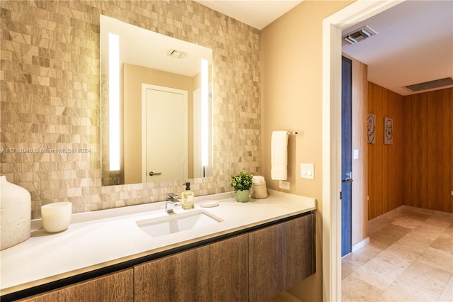 bathroom with decorative backsplash, vanity, and tile walls