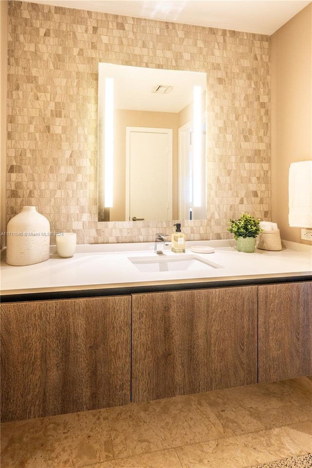 bathroom with vanity and tile walls