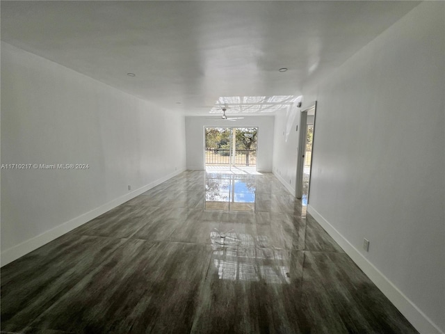 unfurnished room with ceiling fan and dark wood-type flooring