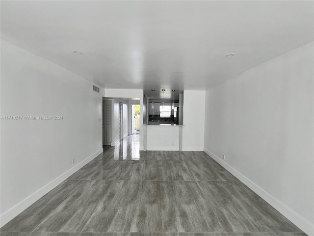 unfurnished living room with dark wood-type flooring