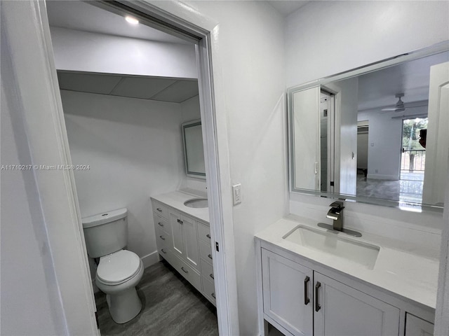 bathroom featuring ceiling fan, hardwood / wood-style floors, vanity, and toilet