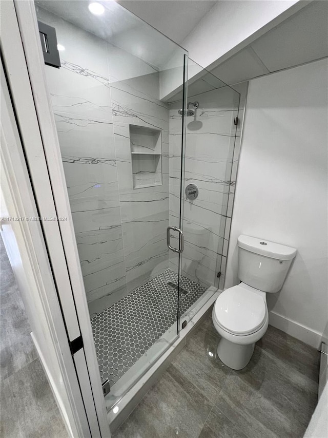 bathroom featuring an enclosed shower and toilet