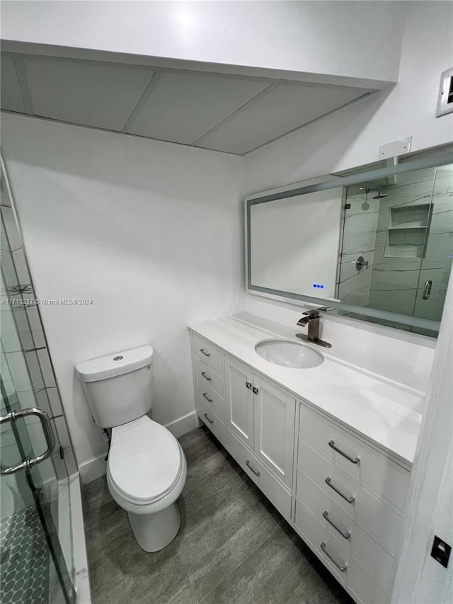 bathroom featuring hardwood / wood-style flooring, vanity, toilet, and an enclosed shower