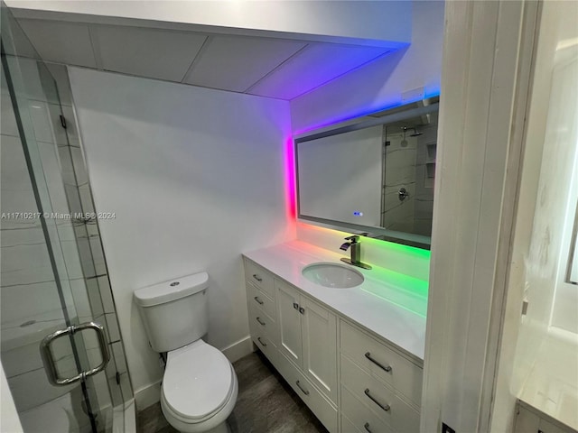 bathroom with vanity, hardwood / wood-style flooring, toilet, and an enclosed shower