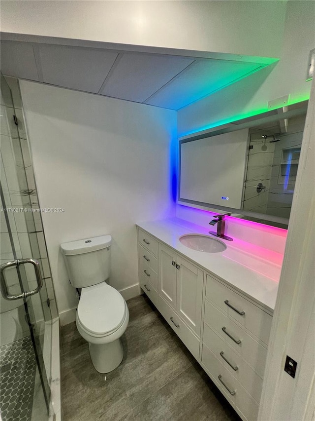 bathroom featuring hardwood / wood-style floors, vanity, toilet, and a shower with door