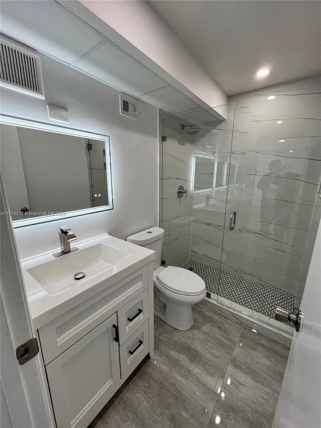 bathroom with vanity, toilet, and an enclosed shower