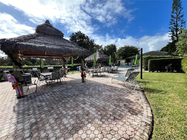 view of property's community featuring a gazebo, a patio area, a lawn, and a pool