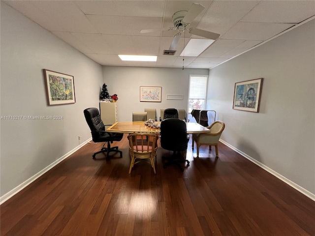 dining space with a paneled ceiling, ceiling fan, and dark wood-type flooring