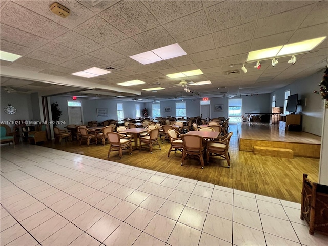 unfurnished dining area with a paneled ceiling and light hardwood / wood-style floors