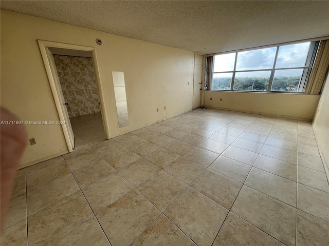 empty room featuring light tile patterned floors and a textured ceiling