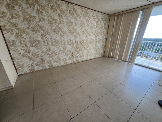 spare room featuring light tile patterned floors and a textured ceiling